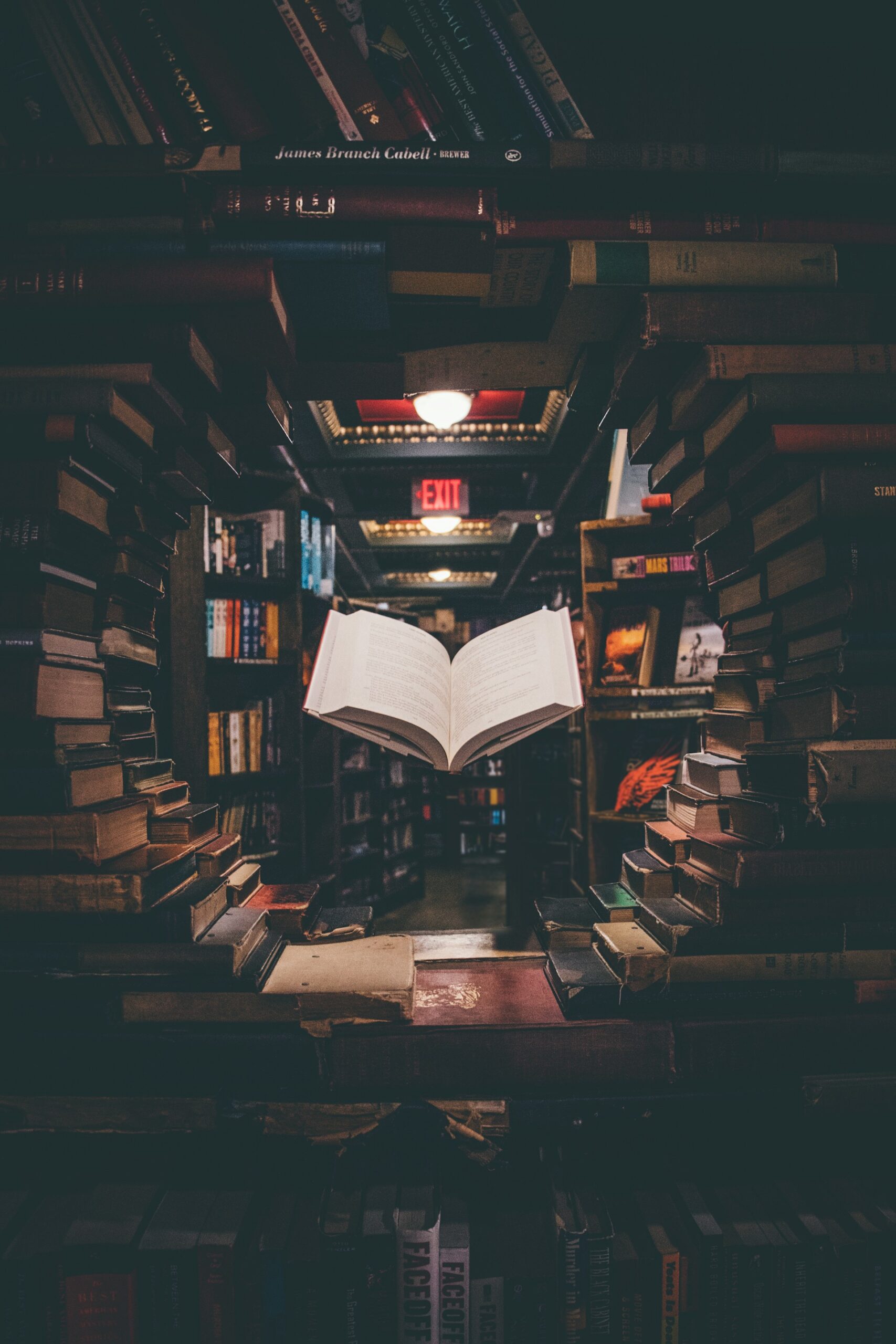 Livro aberto sobre uma pilha de livros em uma biblioteca